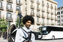 Afro-americano carregando sua bicicleta em seus ombros na cidade — Fotografia de Stock