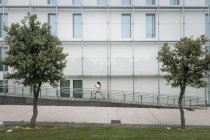 Junge Frau rennt an Gebäude in der Stadt vorbei — Stockfoto