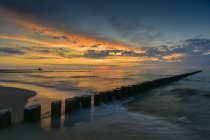 Germany, Mecklenburg-Western Pomerania, Zingst, beach and breakwater at sunset — Stock Photo
