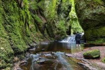 Grande-Bretagne, Écosse, Parc national des Trossachs, canyon Finnich Glen, touriste masculin debout dans l'eau — Photo de stock