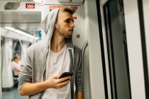 Молодой человек пользуется смартфоном в метро — стоковое фото