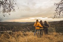 Espanha, Alquezar, três amigos abraçando em uma colina com vista para o cenário — Fotografia de Stock