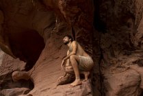 Giovane uomo esplorare grotta — Foto stock