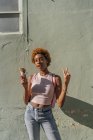 Портрет молодой женщины с рожком мороженого, позирующей у стены — стоковое фото