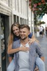 Pays-Bas, Maastricht, jeune couple heureux dans la ville, homme portant une femme sur le dos — Photo de stock