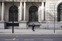 UK, London, stylish senior businessman with briefcase and umbrella standing on pavement — Stock Photo