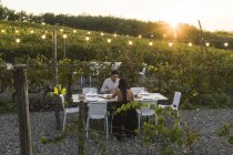 Italy, Tuscany, Siena, young couple having dinner in a vineyard — Stock Photo
