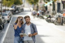 Pays-Bas, Maastricht, jeune couple explorer la ville avec la carte et prendre des photos sur la caméra du film — Photo de stock
