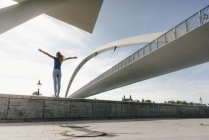 Нідерланди, Маастрихт, молода жінка стоячи на стіні в мосту — стокове фото