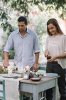 Couple preparing a romantic candlelight meal outdoors — Stock Photo