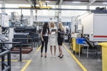 Trois femmes avec tablette parlant dans l'atelier de l'usine — Photo de stock
