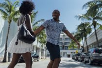 EUA, Flórida, Miami Beach, casal jovem feliz atravessando a rua — Fotografia de Stock