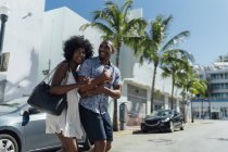 États-Unis, Floride, Miami Beach, heureux jeune couple traversant la rue — Photo de stock