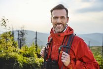 Portrait d'un homme souriant en randonnée dans les montagnes — Photo de stock