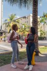 USA, Florida, Miami Beach, two happy female friends having a soft drink in the city — Stock Photo