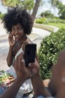 EUA, Flórida, Miami Beach, jovem tirando uma foto de namorada comendo uma salada em um parque — Fotografia de Stock