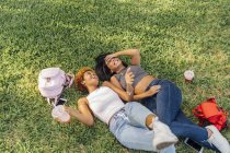 Two carefree female friends relaxing in a park — Stock Photo