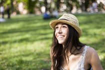 Портрет счастливой молодой женщины в парке, смотрящей что-то — стоковое фото