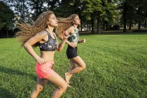 Irmãs gêmeas jogging descalço em um parque — Fotografia de Stock