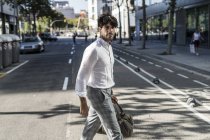 Молодий чоловік в місті перетинає вуличну дорогу — стокове фото