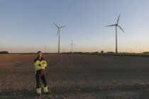 Ingenieur steht auf einem Feld in einem Windpark — Stockfoto