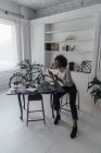 Mujer que trabaja en su oficina en casa, utilizando el ordenador portátil - foto de stock