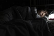 Menina dormindo na cama à noite com luz da noite — Fotografia de Stock