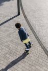 Giovane uomo d'affari in sella skateboard su un quadrato — Foto stock