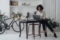 Mujer que trabaja en su oficina en casa, utilizando el ordenador portátil - foto de stock