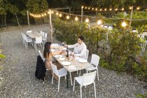 Italy, Tuscany, Siena, young couple having dinner in a vineyard — Stock Photo