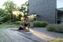 Женщина практикующая йогу в саду — стоковое фото