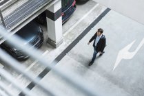 Businessman walking in parking garage — Stock Photo