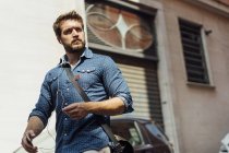 Retrato de homem de negócios usando smartphones e fones de ouvido ao ar livre — Fotografia de Stock