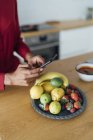Woman taking pictures of fruits on a plate — Stock Photo