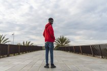 Junger schwarzer Mann steht draußen und schaut über die Schulter — Stockfoto