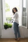 Ritratto di giovane donna attraente in piedi alla finestra — Foto stock