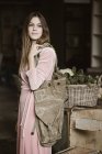 Retrato de mulher jovem com grande saco de compras vestindo vestido rosa de veludo — Fotografia de Stock