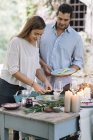 Couple preparing a romantic candlelight meal outdoors — Stock Photo