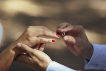 Groom putting wedding ring on finger of bride, close up — Stock Photo