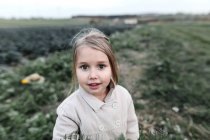 Portrait d'une fille debout sur un champ de choux — Photo de stock