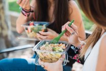 Дівчата сидять в парку і їдять салат. — стокове фото