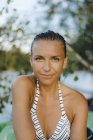 Ritratto di donna sorridente con i capelli bagnati che indossa un bikini in un lago — Foto stock