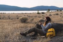 USA, California del Nord, giovane barbuto che usa il cellulare durante una pausa durante una gita nei pressi del Parco Nazionale Vulcanico di Lassen — Foto stock