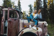 Dois amigos sentados em um caminhão quebrado — Fotografia de Stock