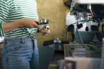 Close-up of young woman preparing coffee in a cafe — Stock Photo