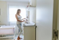 Беременная женщина готовит детскую комнату — стоковое фото