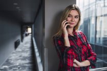Портрет молодої жінки по телефону в сучасному офісному корпусі — стокове фото