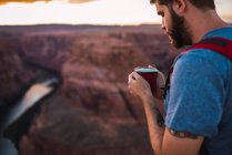 USA, Arizona, Horseshoe Bend, Young man holding red cup — стокове фото