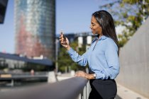 Businesswoman using smartphone in city — Stock Photo