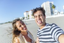 Drôle selfie d'un jeune couple heureux sur la plage — Photo de stock
